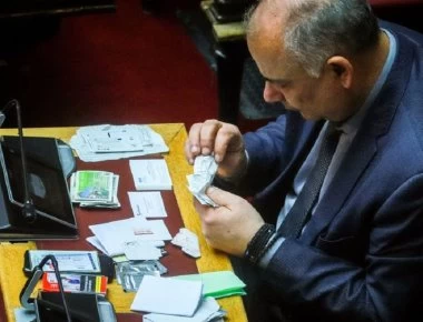 Βουλή: Ο Σαρίδης περιεργάζεται προσωπικά του αντικείμενα - Αράδειασε στο έδρανο μαντιλάκια και αποκόμματα ΟΠΑΠ! (φωτο)